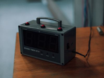 Glass of water and sports timer on a dark table